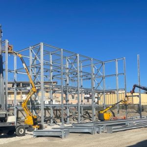 montaggio strutture metalliche con gru e piattaforme aeree in cantiere